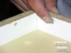 לחיצה להגדלת תמונה ממלאים את חורי הקדיחה בלוחות המסגרת בעזרת חימר נטול גופרית.