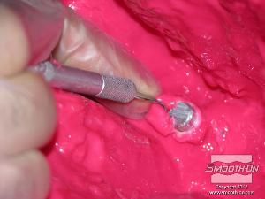 לחיצה להגדלת תמונה מאתרים את הברגים המוטבעים בחימר וחותכים את תבנית הסיליקון Rebound® 25 כדי לחשוף אותם.