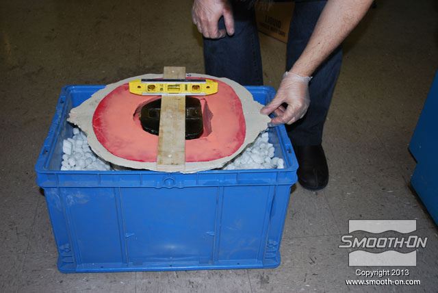 שמים את התבנית בתוך קופסה מלאה בבוטני קלקר  ומפלסים אותה.