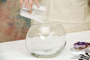 לחיצה להגדלת תמונה שופכים כוס של כדורי זכוכית קטנים לכלי הזכוכית הגדול, כדי ליצור את בסיס התצוגה.