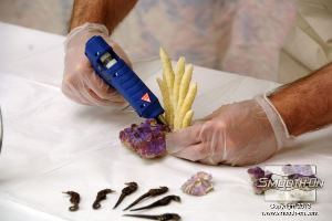 לחיצה להגדלת תמונה מדביקים את חתיכות האלמוגים ביחד בעזרת דבק חם.