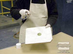 לחיצה להגדלת תמונה מרססים חומר הפרדה על לוח המכסה ששומר את השרף בתוך התבנית ויוסר לאחר היציקה.