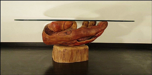 לחיצה להגדלת תמונה בסיס השולחן – כף יד ימין בעלת שש אצבעות עם הכיתוב “prepare to die”. השולחן עשוי אקליפטוס אדום על בסיס עץ מכנף נאה ומשטח זכוכית. העצים מחוברים באמצעות מוטות ברזל ודבק אפוקסי.