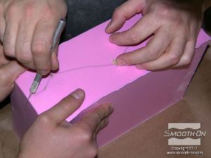 לחיצה להגדלת תמונה חליצת המודל: קו הסימון שצוייר על לוח הבסיס עבר לתבנית וכעת ניתן לבצע חתך בתבנית לאורכו. מומלץ להשתמש עזרת אדם נוסף שיפריד את שני צידי התבנית בזמן ביצוע החתך.