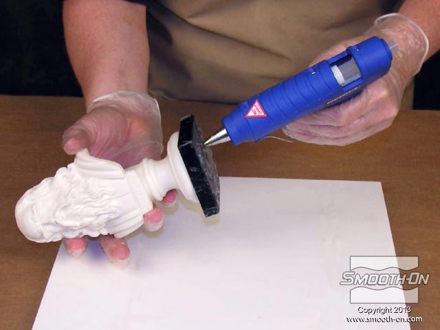 מדביקים את המודל ללוח הבסיס בעזרת דבק חם, כדי למנוע ממנו לזוז במהלך תהליך הכנת התבנית.