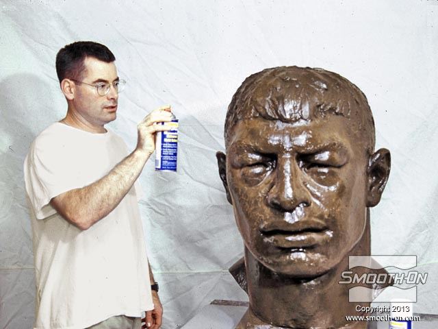 הפסל טים מאסלין מרסס חומר הפרדה על משטח המודל המקורי.