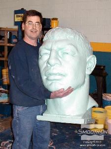 לחיצה להגדלת תמונה הפסל טים מסלין מחזיק יציקה של פסל 'המנצח' העשוייה מפוליאוריטן Smooth-Cast 65D®. ביציקה זו מרחו אבקת אפקט Cast Magic® pearly green ליצירת אפקט. 