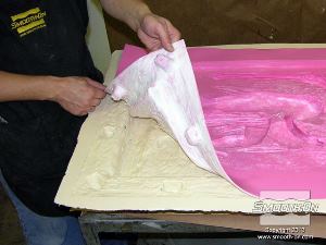 לחיצה להגדלת תמונה ממקמים את תבנית סיליקון Mold Max® Stroke® בתוך מעיל התמיכה. מפחות הנעילה שהוספו בשלב קודם מקלים מאוד על המשימה.