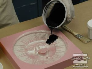 לחיצה להגדלת תמונה כשהחומרים מעורבבים כראוי, שופכים את שרף הSmooth-Cast ®300 לנקודה אחת בתבנית.