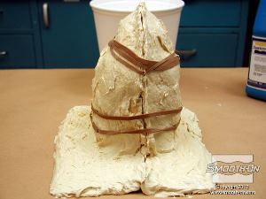 לחיצה להגדלת תמונה ממקמים את תבנית הסיליקון Dragon Skin® 10 FAST בתוך מעיל התמיכה מפוליאוריתן Plasti-Paste. סוגרים את מעיל התמיכה עם גומיות דואר.