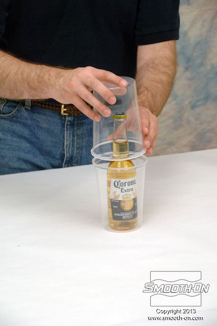 משתמשים בשתי כוסות חד פעמיות בגודל 900 גרם כדי להכיל את ה סיליקון שקוף כמו מים Encapso® K בזמן שהוא הופך מנוזל למוצק.