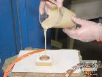 שופכים את נוזל פוליאוריטן מוקצף Foam-iT!® 5 המעורבב דרך החור אל היציקה.