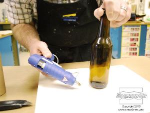 לחיצה להגדלת תמונה מחזיקים את הבקבוק במקומו עד שהדבק מתקרר.