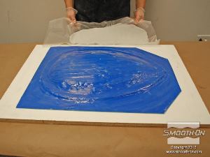 לחיצה להגדלת תמונה ממקמים את בצק האפוקסי Free Form (כשנייר השעווה עוד עליו) על תבנית הגומי, כדי ללחוץ אותו למקומו.