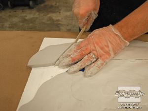 לחיצה להגדלת תמונה חותכים עודפי חומר מ בצק אפוקסי Free Form בעזרת מקל עץ בזמן שהוא עדיין לא התמצק לחלוטין.