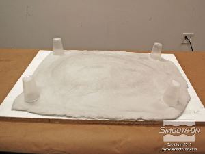 לחיצה להגדלת תמונה ממקמים 4 כוסות פלסטיק בפינות הבצק כדי להעריך את המיקום הנכון עבור רגלי התמיכה לתבנית.