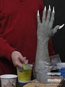 לחיצה להגדלת תמונה בדוגמה זו, משתמשים במברשת רגילה לחתולים על גבי צלופן כדי העניק לבצק האפוקסי Free Form® Earth כדי להעניק לו מרקם של עור רך.