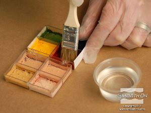 לחיצה להגדלת תמונה טובלים את המברשת עם האלכוהול בצבע האדום של האיפור.