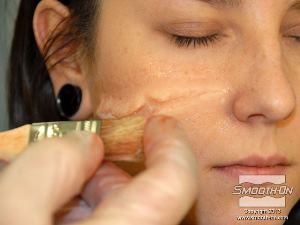 לחיצה להגדלת תמונה מפזרים את האיפור על פני העור בעזרת המברשת. 