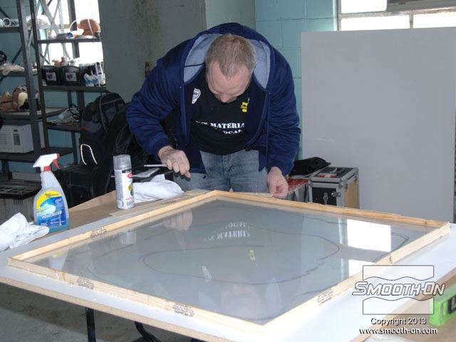 אומן האפקטים אריק פורן מסדר לוח קוולר על בסיס ובונה מסגרת תבנית בעזרת לוחות ודבק.