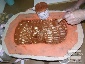 לחיצה להגדלת תמונה מורחים ביסודיות את אבקת הברונזה על משטח התבנית תוך הקפדה על מריחת הפרטים העמוקים וצידי חלל התבנית.