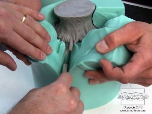 לחיצה להגדלת תמונה כדי לחלוץ את המודל מתבנית הסיליקון Mold Star® 15, עושים בה ארבעה חתכים. מומלץ להעזר באדם נוסף שיחזיק את התבנית פתוחה בזמן החיתוך.