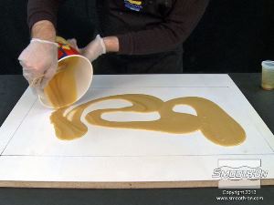 לחיצה להגדלת תמונה שופכים את הקצף על לוח הבסיס בצורה אקראית, בתוך קווי המתאר שסומנו קודם לכן.  פוליאורתן מוקצף קשיח Foam-iT!®5 מתפשט לנפח של פי 10 מנפחו הנוזלי.