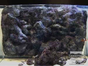 לחיצה להגדלת תמונה מגנט הניקוי לאקווריום מחזיק את רקע הסלע מקצף פוליאוריטן קשיח במקום. ניחתן לחבר מספר אריחי קצף כאלה כדי לכסות משטח אקווריום גדול יותר.