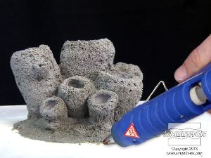 לחיצה להגדלת תמונה מדביקים את המודל המקורי ללוח בסיס ממלאמין בעזרת דבק חם, כדי להבטיח שהמודל לא יצוף בסיליקון הנוזלי בזמן היציקה וימנע מהסיליקון לזרום מתחת למודל.