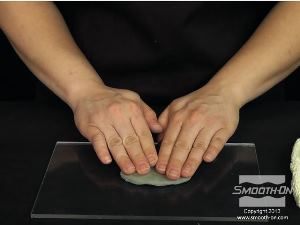 לחיצה להגדלת תמונה מפסלים את פיסת החימר לצורת אליפסה שטוחה (בגודל פרופורציוני למודל) ומהדקים אותה ללוח הבסיס מאקריליק.