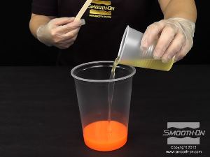 לחיצה להגדלת תמונה מעבירים את מקשה הפוליאוריתן הקשיח Smooth-Cast® 325 הצבוע למיכל ערבוב גדול יותר.