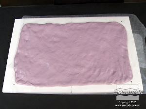 לחיצה להגדלת תמונה בצק הסיליקון Equinox® 40 מכסה באופן אחיד את לוח הבסיס המכוסה בנייר שעווה.