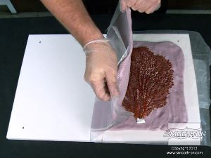 לחיצה להגדלת תמונה מקפלים את תבנית בצק הסיליקון Equinox® 40 על המודל בעזרת נייר השעווה. משתדלים לקפל את התבנית כמה שיותר במרכזה.