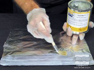 לחיצה להגדלת תמונה מורחים על נייר האלומיניום חומר הפרדה Sonite Wax כדי למנוע מהפוליאוריתן הנוזלי להדבק אליו. לאחר שמשטח האלומיניום מכוסה, מניחים לשעווה להתייבש במשך 15 דקות.