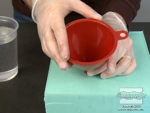 לחיצה להגדלת תמונה מרכיבים מחדש את שני חצאי תבנית הסיליקון Mold Star ומכניסים משפך לצינור היציקה שיצרנו בתבנית, כדי למזער שפיכה של חומר על התבנית.