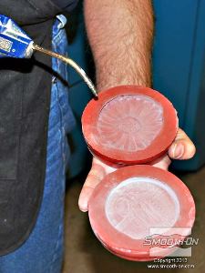 לחיצה להגדלת תמונה משתמשים בלחץ אוויר כדי למנוע הצטברות טלק בתוך פרטי התבנית. כך מתקבל ציפוי טלק דק מאוד על גבי תבנית הסיליקון.