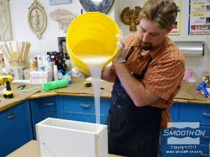 לחיצה להגדלת תמונה שופכים את סיליקון Mold Max 15T אל תוך קופסת התבנית באיטיות.