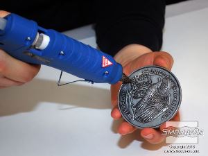 לחיצה להגדלת תמונה יש לקבע את המטבע למשטח עבודה מפולס בעזרת אקדח דבק חם