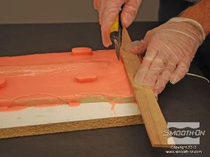 לחיצה להגדלת תמונה לאחר שהסיליקון התמצק לחלוטין, משתמשים בחפץ ישר כדי לחתוך את קצוות הסיליקון וליצור תבנית ישרה ויפה.