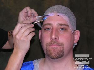 לחיצה להגדלת תמונה מקבעים את הכובע לעור המודל.