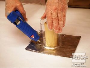 לחיצה להגדלת תמונה בעזרת דבק חם, אוטמים את קו התפר בין גליל העץ לנייר האלומיניום כדי למנוע מגומי סיליקון לזרום מתחת לעץ.