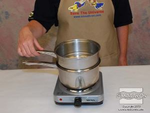 לחיצה להגדלת תמונה שמים את הסיר הקטן יותר על הסיר הגדול עם המים.